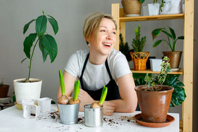 Portrait of young woman sitting on table at home