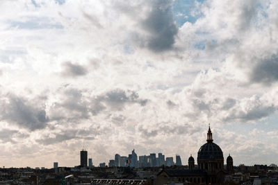 Cityscape against cloudy sky