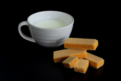 Close-up of coffee cup on table against black background