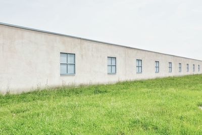 Building on field against clear sky