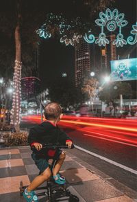 A child rides a stroller on the side of the road.