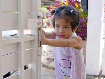 Cute girl pushing gate at entrance