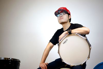 Full length of senior man sitting against white background