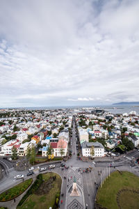 Aerial view of cityscape against cloudy sky