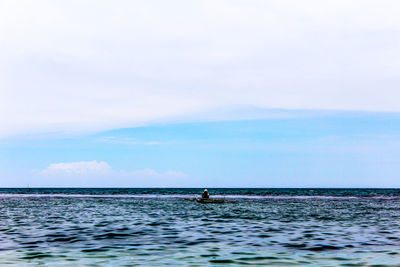 Man surfing in sea against sky