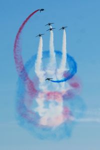 Low angle view of airshow against sky