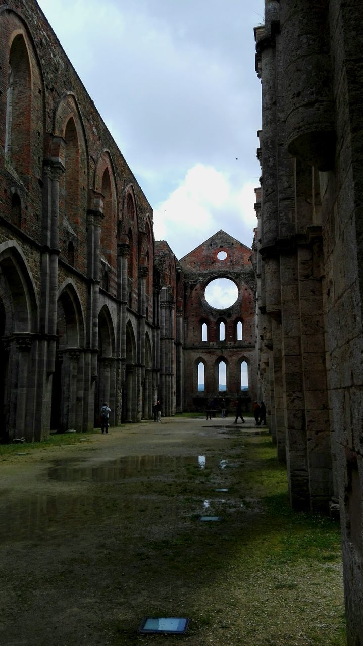 architecture, building exterior, built structure, sky, arch, cloud - sky, travel destinations, cloud, facade, lawn, day, history, outdoors, the way forward, in front of, cloudy, old town, mountain, surface level, town, no people, arcade