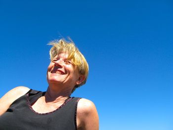 Portrait of young woman against clear sky