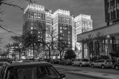 Traffic on city street by buildings against sky