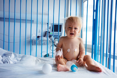 Portrait of cute baby boy lying on bed at home