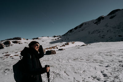 Rear view of man standing on snow covered mountain