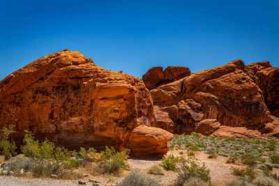 Rock formations on mountain against blue sky