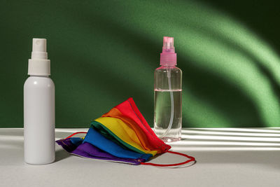 Close-up of multi colored mask and bottles on table