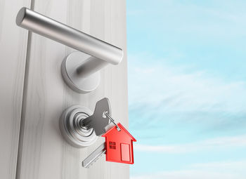 Low angle view of key hanging on door against sky