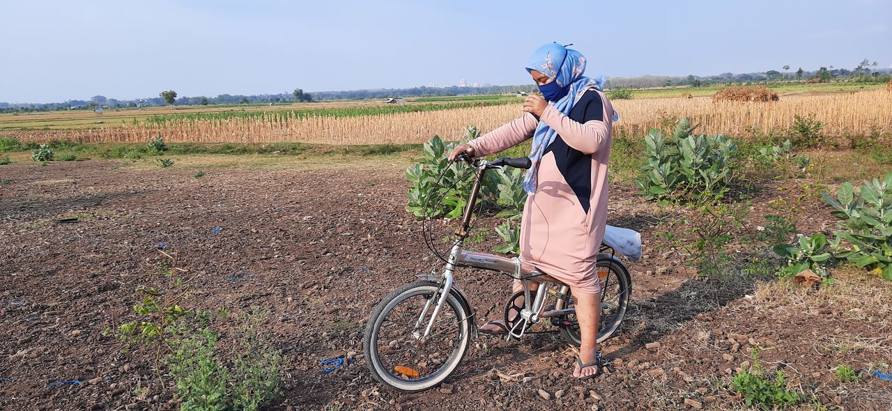 PERSON RIDING BICYCLE ON FIELD