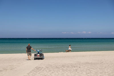 People on beach against sky