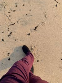 Low section of woman standing on sand