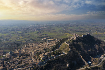 Aerial view of the castle of assisi umbria with the city in the background at sunrise