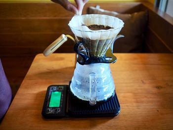 Close-up of hand pouring coffee cup