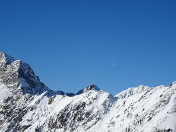 Scenic view of snowcapped mountains against clear blue sky