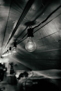 Low angle view of light bulb hanging from ceiling