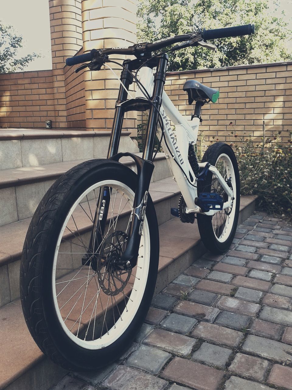 bicycle, building exterior, architecture, built structure, transportation, land vehicle, mode of transport, stationary, parked, parking, street, wall - building feature, city, sidewalk, day, outdoors, brick wall, wheel, building, sunlight