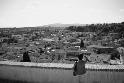 Man looking at cityscape against sky