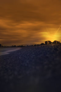 Surface level of land against sky during sunset