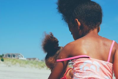 Sisters at beach on sunny day