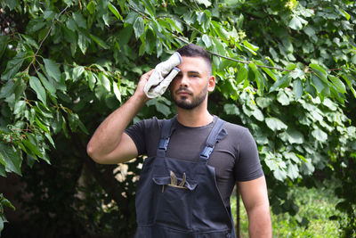 Young man standing against plants