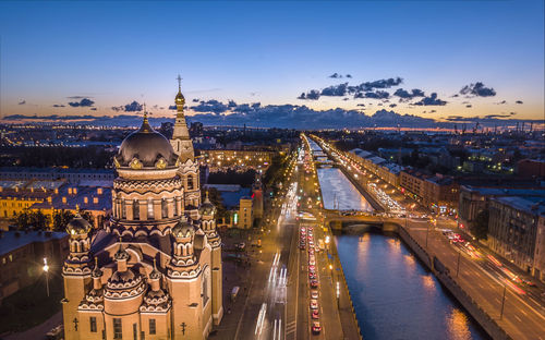 Illuminated cathedral by street in city against sky