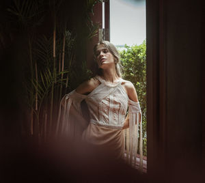 Woman standing by window at home