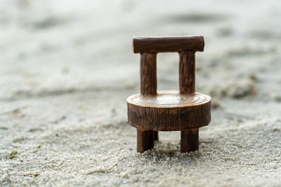 Close-up of empty bench on beach