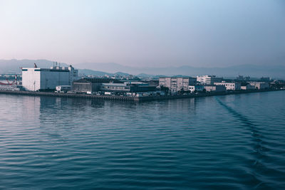 Residential district by sea against clear sky