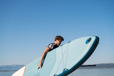 Man on boat against clear blue sky