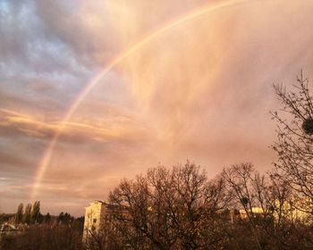 Low angle view of rainbow against sky at sunset