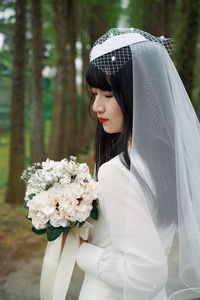 Young woman holding white flower