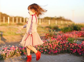 Full length of woman standing on flowering plant