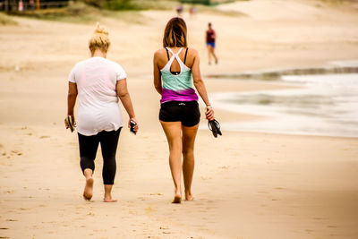 Rear view of women walking on beach