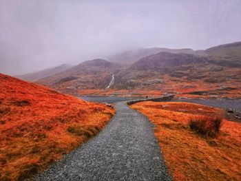 Road amidst landscape against sky during autumn