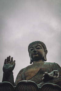 Low angle view of buddha statue against sky