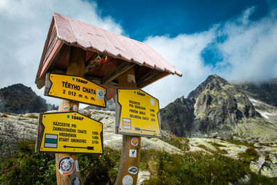 Information sign on mountain against sky