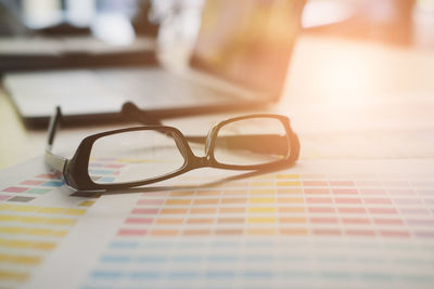 Close-up of eyeglasses on color swatch at desk