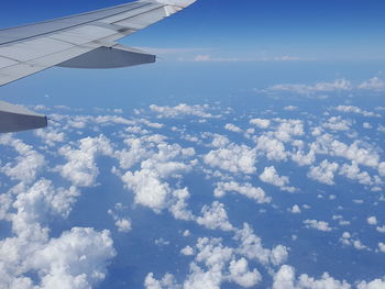 Aerial view of airplane wing over clouds