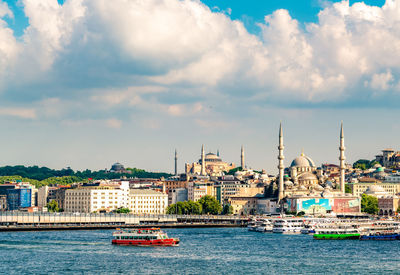 View of buildings at waterfront against cloudy sky