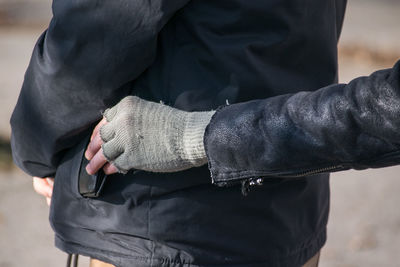 Cropped hand of thief stealing wallet of man