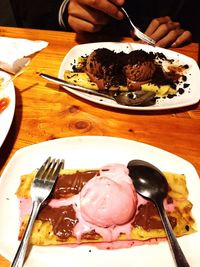 Close-up of hand holding ice cream on table