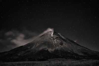 Scenic view of snowcapped mountain against sky at night