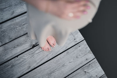 Low section of woman standing on wooden table