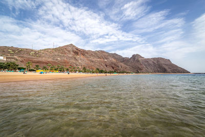 Scenic view of sea and mountains against sky